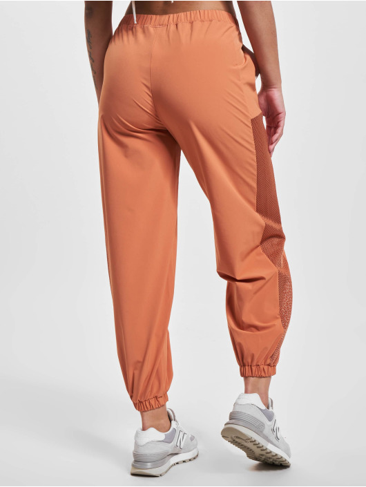 New Balance Látkové kalhoty All Terrain Hose oranžový